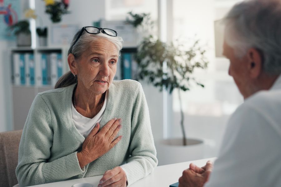 Hospital, doctor and patient with chest pain, healthcare or medical appointment for help or talking