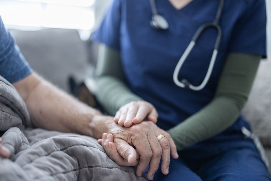 Nursing holding hospice patient's hand